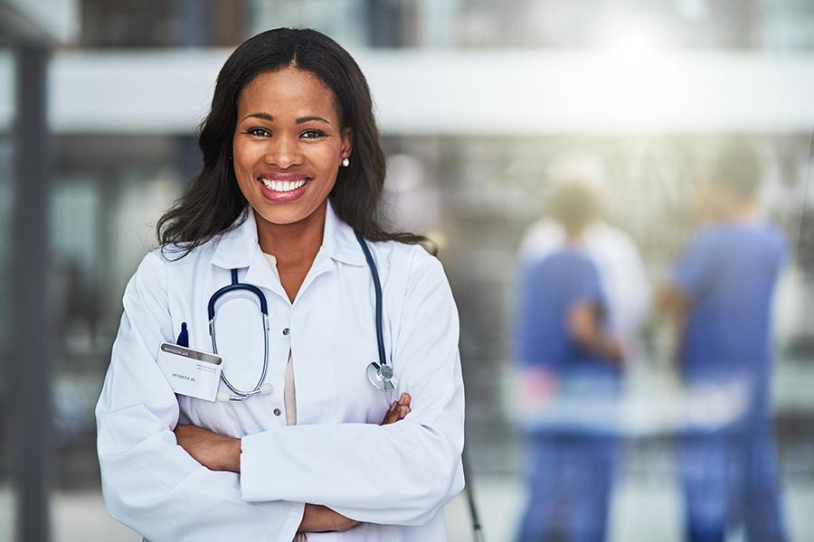 Student smiling in a white lab coat.